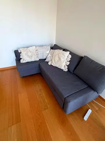Compact L-shaped grey fabric sofa bed with topper