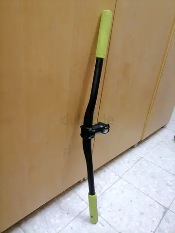 Used straight bicycle handlebar with stem and green grips