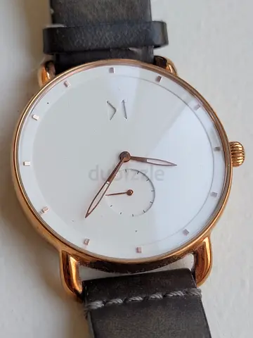 Minimalist rose gold wristwatch with white dial and leather strap