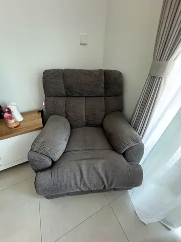Single grey fabric recliner armchair in good condition