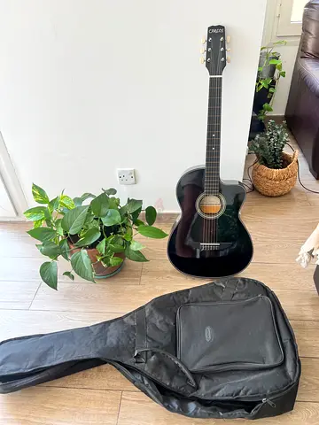 Black full-size acoustic guitar with soft gig bag - used