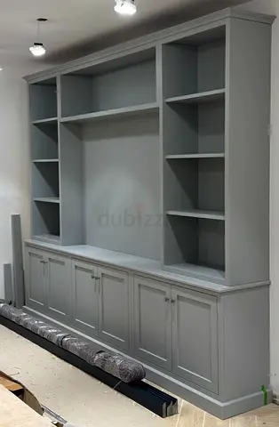 Custom built-in grey media wall unit with cupboards and open shelving
