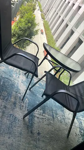 Compact balcony bistro set — glass top table with two mesh chairs