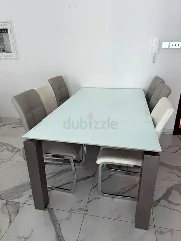 Modern glass-top dining table with 6 upholstered chairs