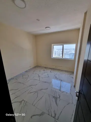A premium apartment for annual rent in Al Bu Tina, Sharjah. The apartment features one bedroom, a spacious living room, one bathroom, modern finishing