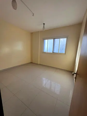 2BR apartment for rent in Al Musalla, behind Grand Mall. Family & bachelor friendly, sandy parking, AED 38,000/year, 6 cheques, fee AED 1,500.