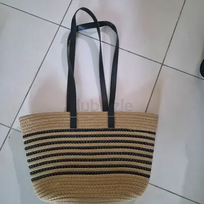 Striped straw tote bag with long black shoulder straps