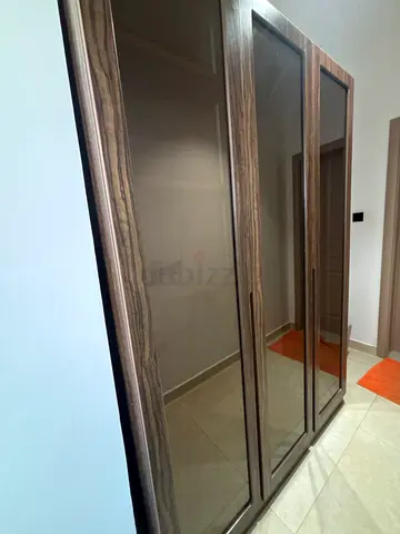 Three-door wooden wardrobe with light with  mirrored panels - good condition