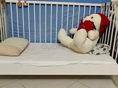 White wooden crib/ toddler bed with mattress