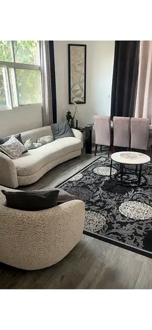 Cozy curved sofa set with patterned black rug — good condition