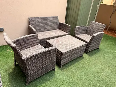 4-piece grey rattan outdoor patio sofa set with coffee table and seat covers - good condition