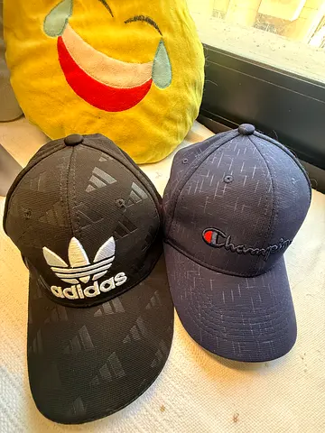 Two branded black baseball caps (Champion + Adidas)
