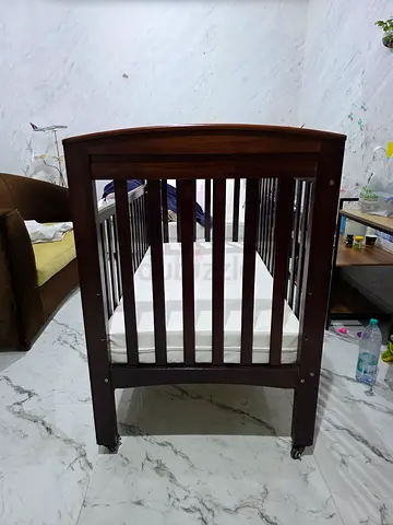 Dark wood baby crib in good condition - convertible style