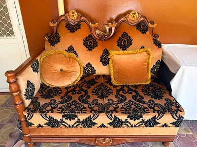 Carved wooden 13-seater sofa with patterned upholstery