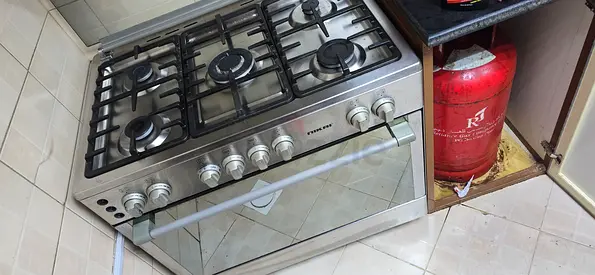 Freestanding 5-burner stainless steel gas stove with oven - used. Comes with gas cylinder