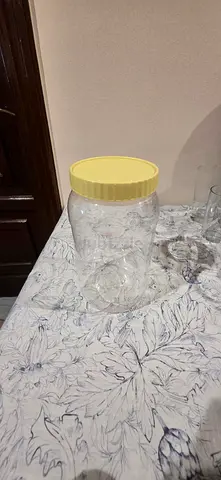 Large clear plastic storage jar with yellow lid - good condition