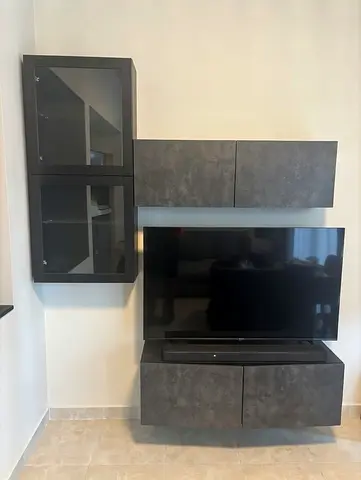 Modern IKEA wall-mounted TV unit with glass cabinet and storage