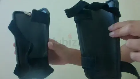 Pair of black football shin guards with straps