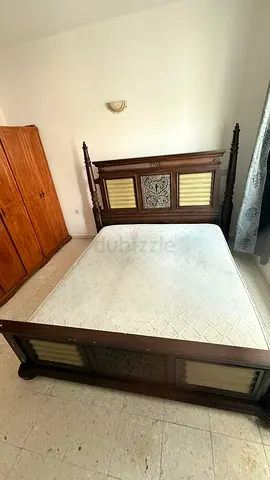 Classic Wooden Bed Frame with Carved Details and Mattress