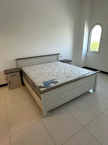 King size bed frame with mattress and two bedside tables - light wood finish