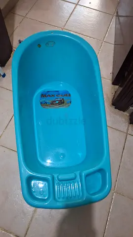 Blue plastic baby bath tub with built-in soap and accessory trays