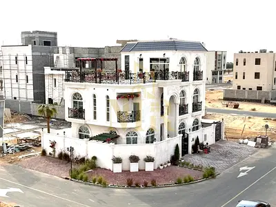 In Al Bahia, Ajman, a corner villa with two floors and a rooftop terrace, fully air-conditioned, freehold ownership for all nationalities.