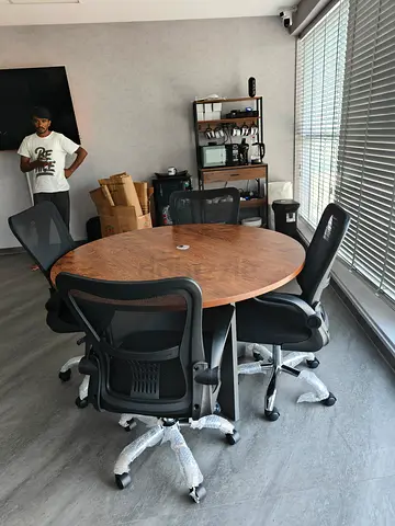 Round wooden meeting table with 6 ergonomic office chairs