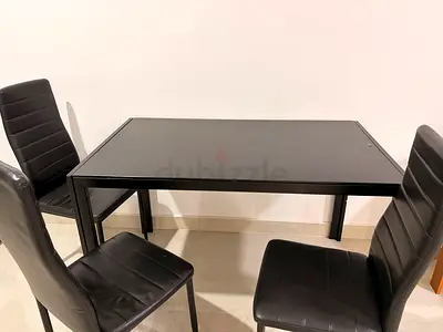 Black dining table with 4 matching faux-leather chairs - good condition.