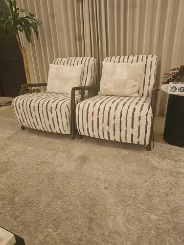 Pair of modern metal-frame lounge chairs with cushions