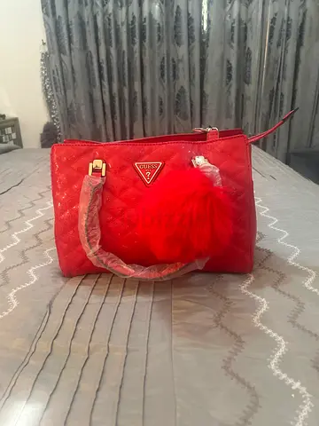 Red quilted handbag with pompom charm - like new