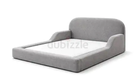 Low-profile grey upholstered platform bed with rounded headboard