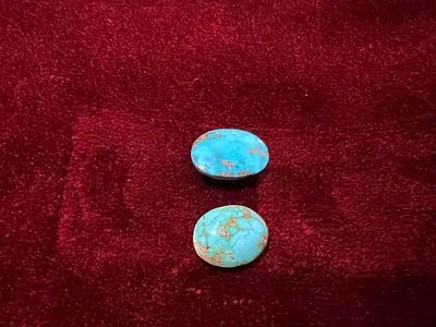 Pair of oval turquoise cabochon stones — blue-green with matrix
