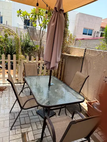 Outdoor glass-top dining table with 4 chairs and umbrella