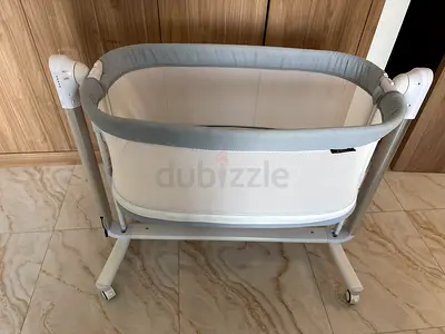 Used self rocking bedside bassinet / cradle with mesh sides and wheels - excellent condition
