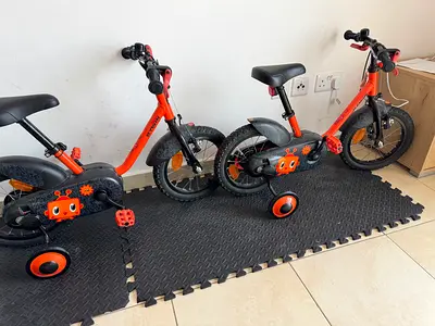 Pair of matching kids 12-inch training bikes with removable stabilizers - orange/black
