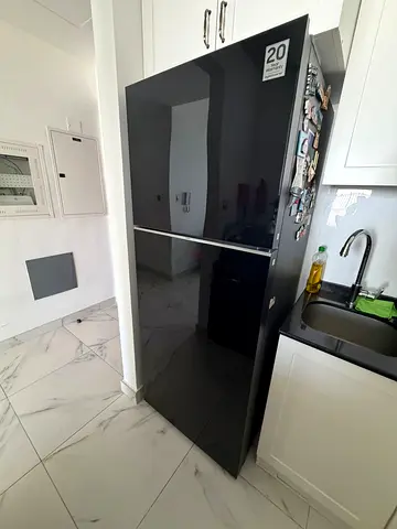 Black double-door refrigerator - good condition, 20-year warranty sticker