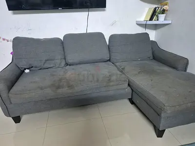 Grey L-shaped fabric sofa with chaise — used, needs cleaning