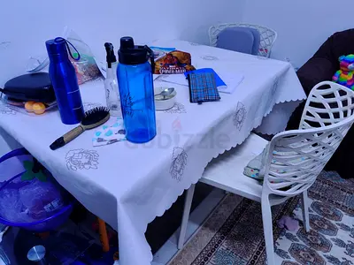 White dining table with 2 modern chairs and tablecloth - used
