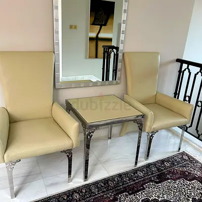 Pair of cream upholstered accent chairs with metal side table