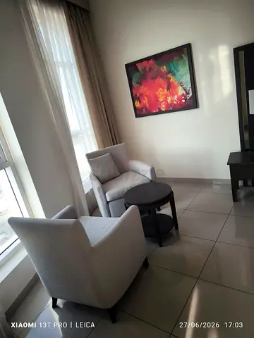 Two grey armchairs with round nesting table