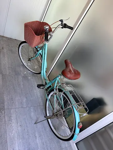 Light blue city/commuter bicycle with front basket and rear rack