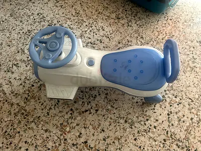 Blue plastic ride-on car for toddler with steering wheel and horn