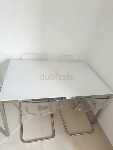 White glass dining table with chrome legs and 4 transparent chairs