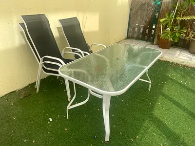 Outdoor glass-top dining table with 4 reclining chairs