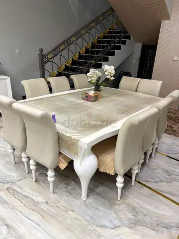 White wooden dining table with 10 upholstered chairs - good condition