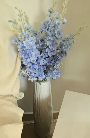 Tall decorative floor vase with artificial blue hydrangea stems