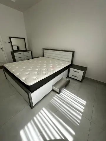 King size bed frame with mattress, matching bedside tables, and dresser with mirror