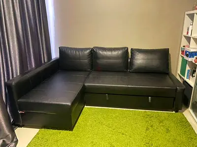 Black L-shaped faux leather sofa with storage - good condition