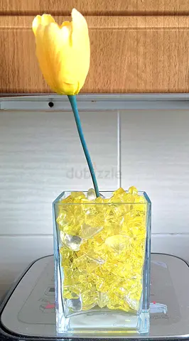 Artificial yellow tulip in glass vase with decorative crystals