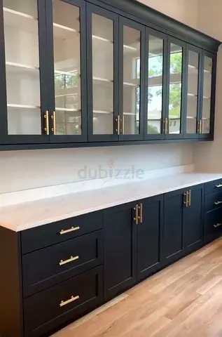 Dark Blue Kitchen Cabinets with Glass Upper Doors and Brass Handles